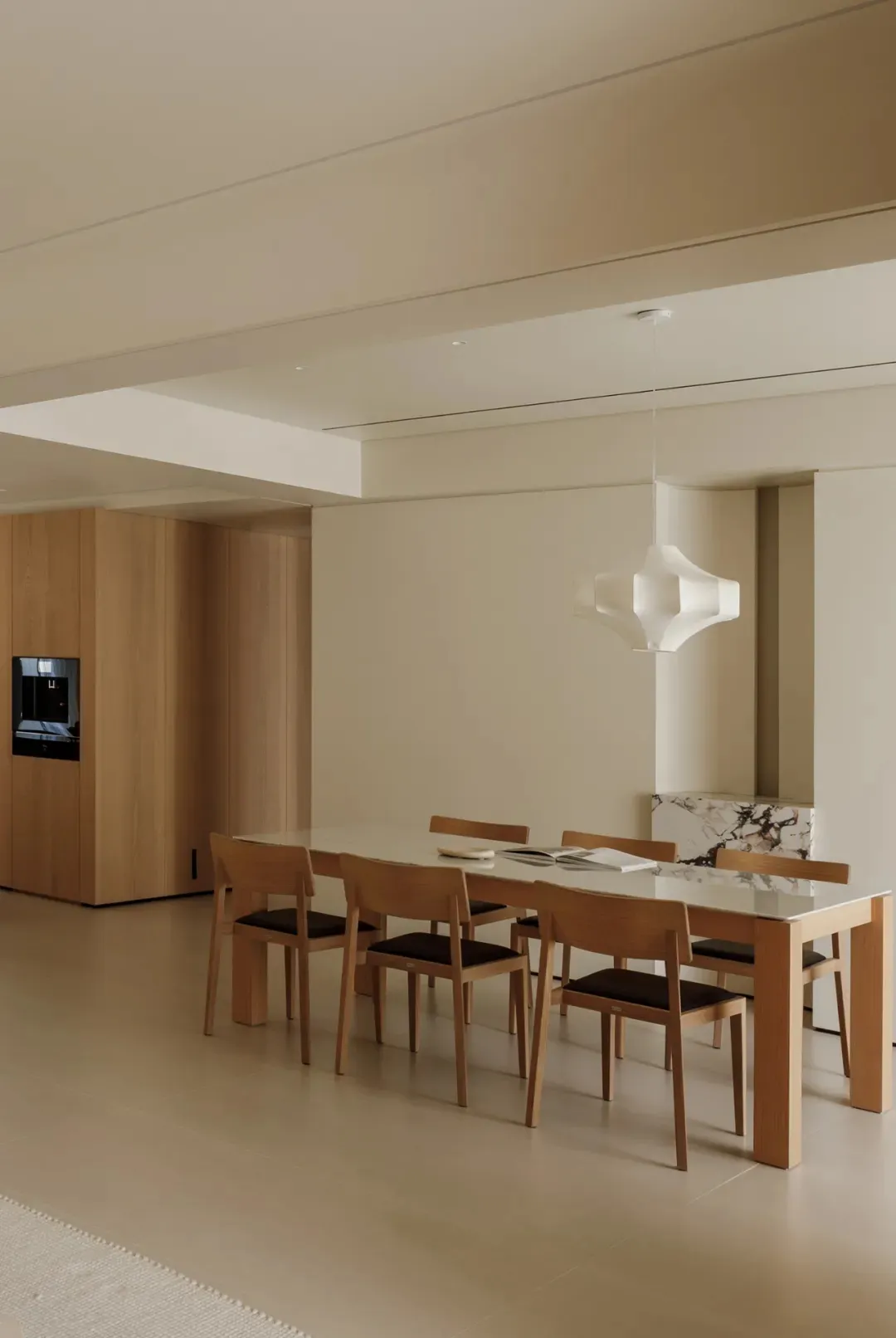 A modern residential dining room with a wooden floor, table, and chairs.