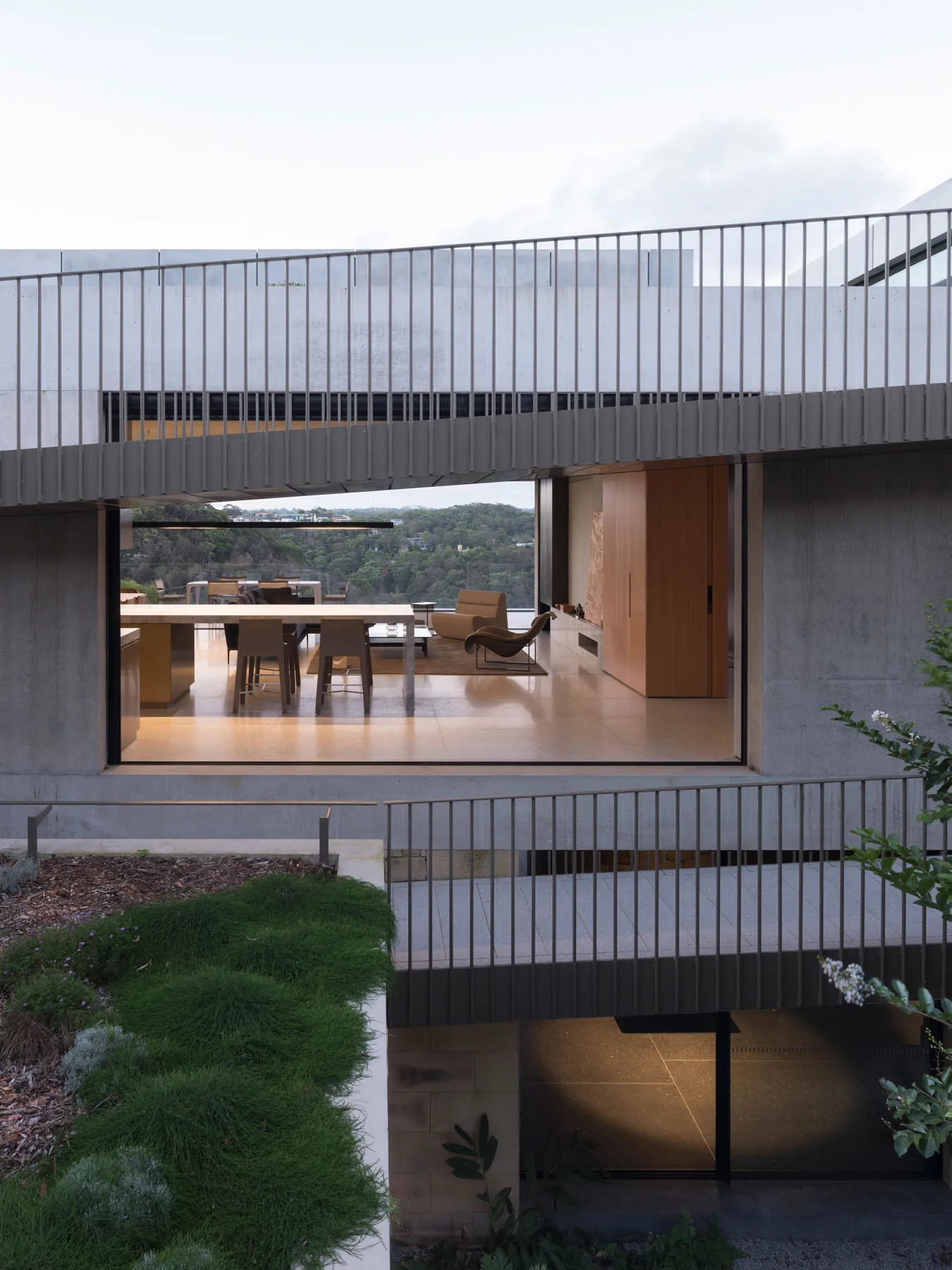 A modern residential interior with concrete walls and glass elements.
