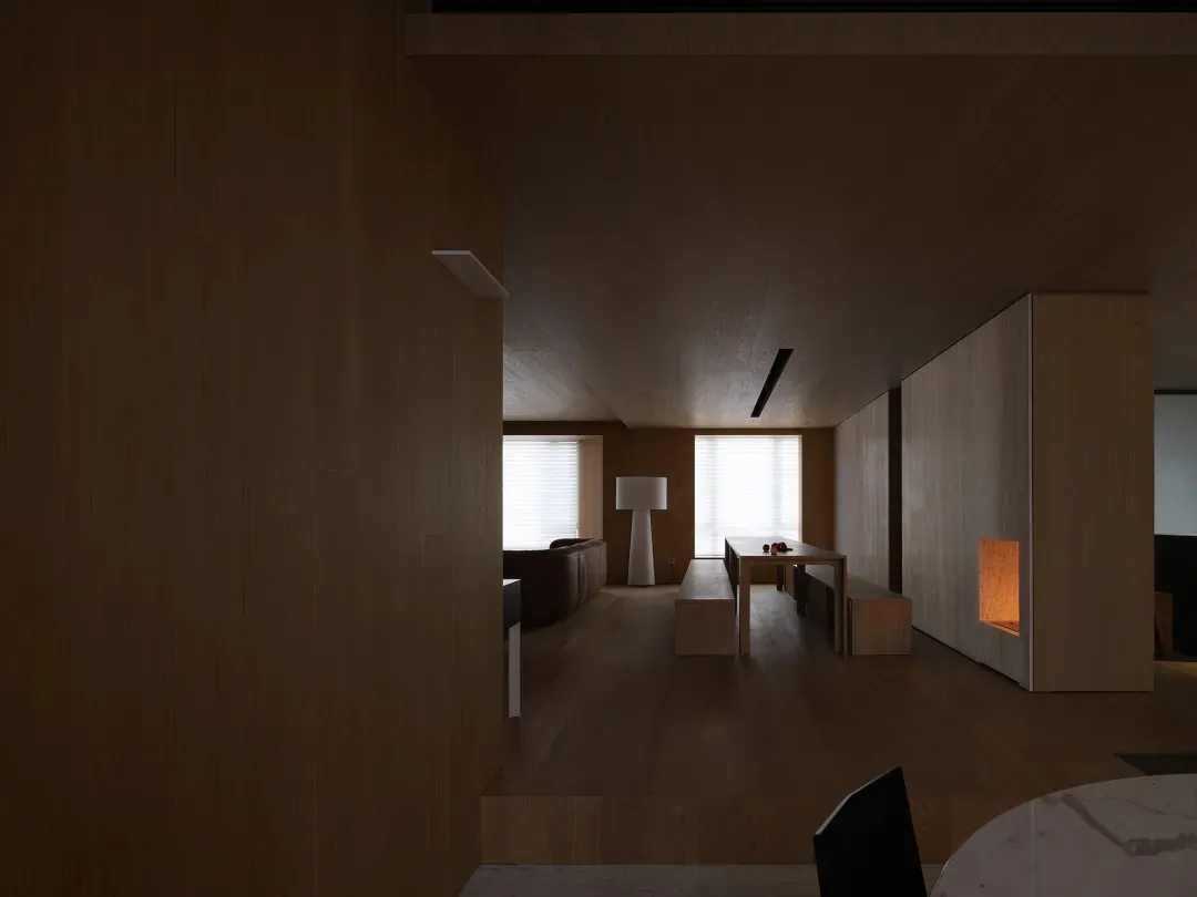 Modern minimalist living room with wooden ceiling, floor, and furniture, featuring a sleek white lamp and a warm, inviting fi
