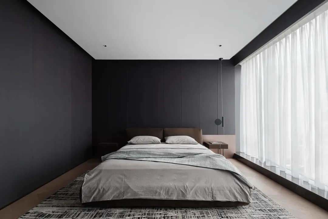 Minimalist bedroom featuring textured wallpaper, modern furniture, and soft lighting.