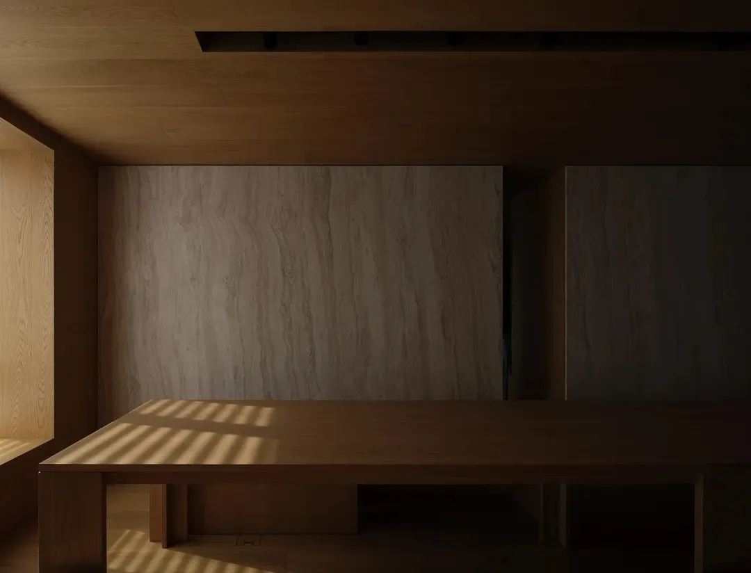 Well-lit minimalist room with wooden walls and floor, featuring a large wooden table casting shadows.