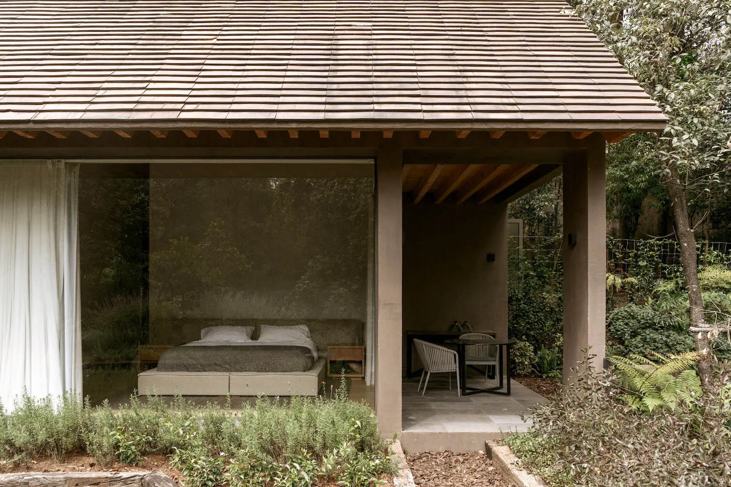 A minimalist residential space featuring wood, glass, and cement materials.