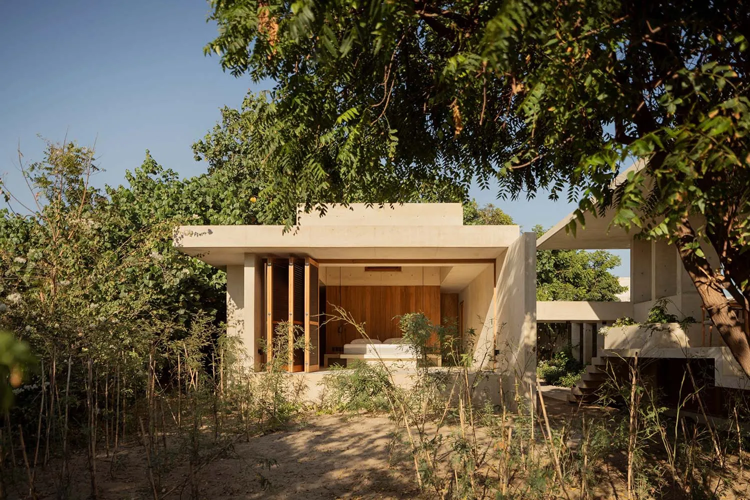 A minimalist residential space featuring a concrete exterior and open-air design.