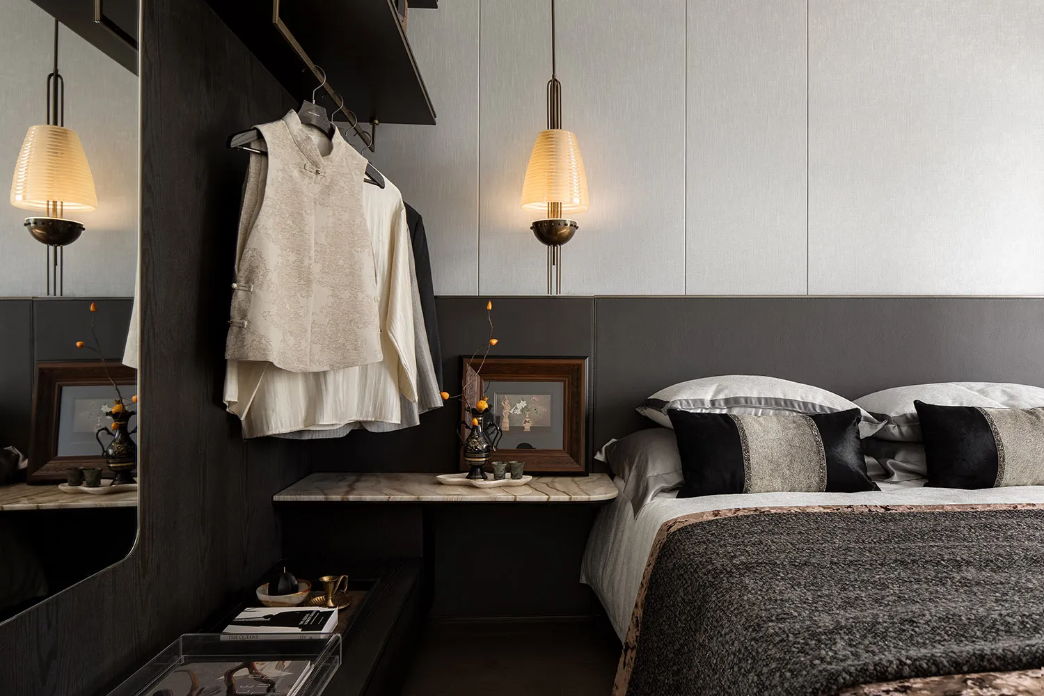 A modern minimalist bedroom with a dark wood headboard, white bedding, and a marble nightstand.