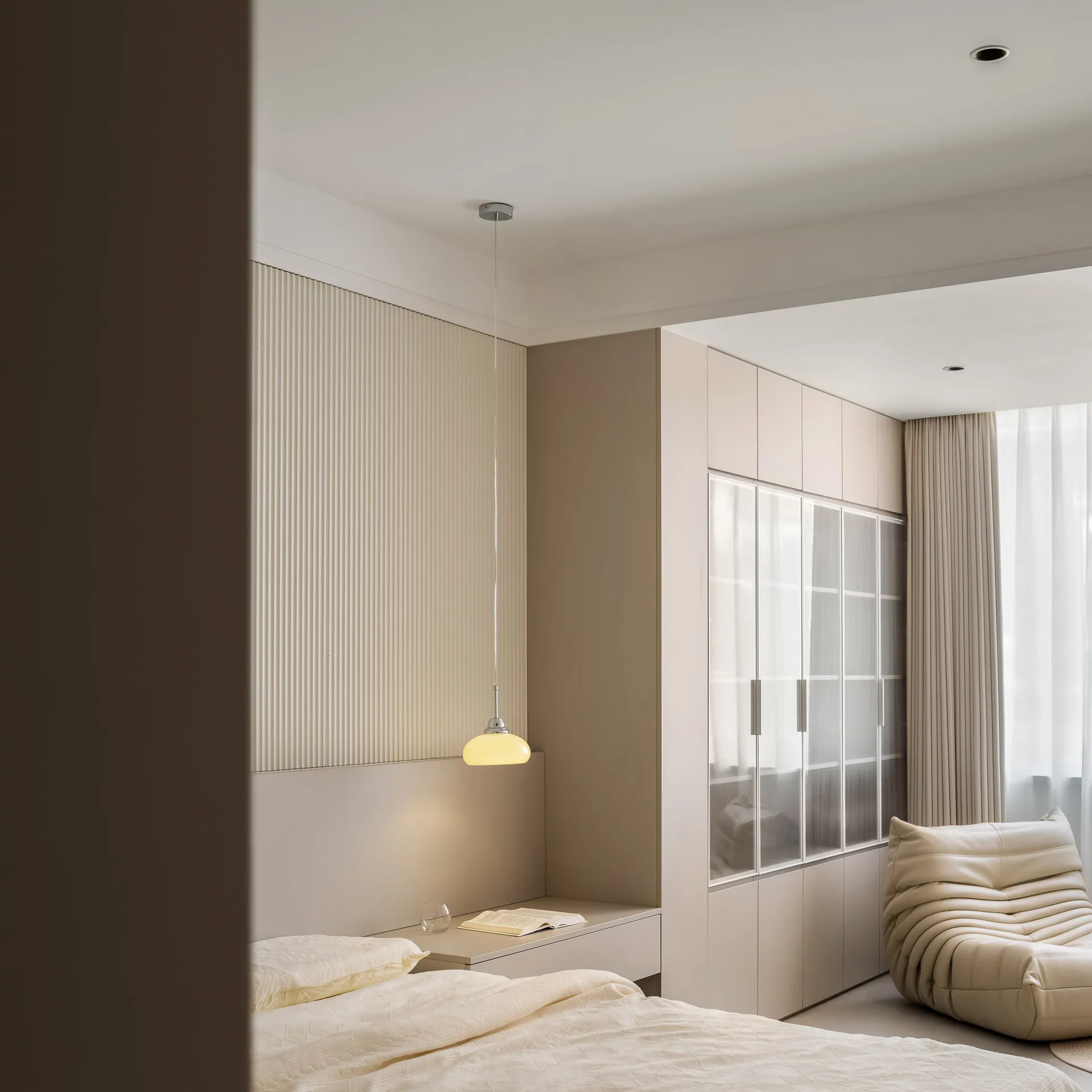 Minimalist bedroom with taupe fabric and laminate finishes.