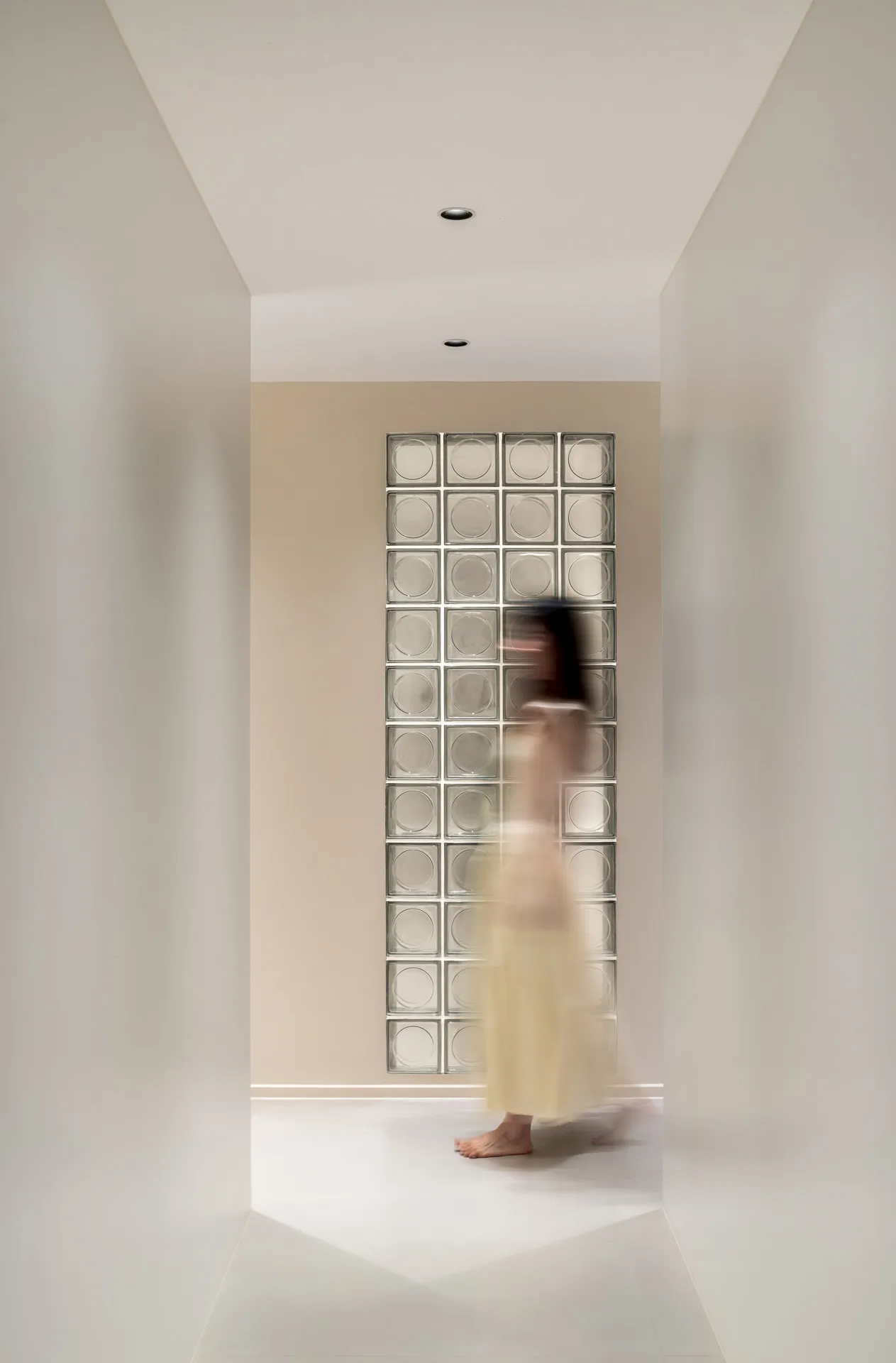 A minimalist interior with glass blocks in a light-colored corridor