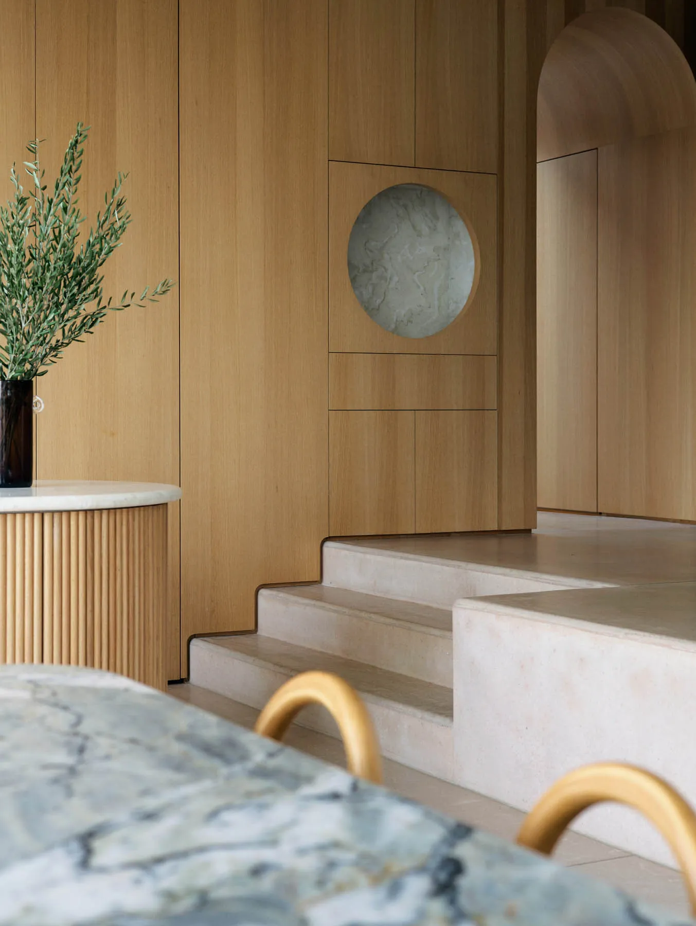 Modern kitchen featuring minimalist design with marble countertops and wooden elements.