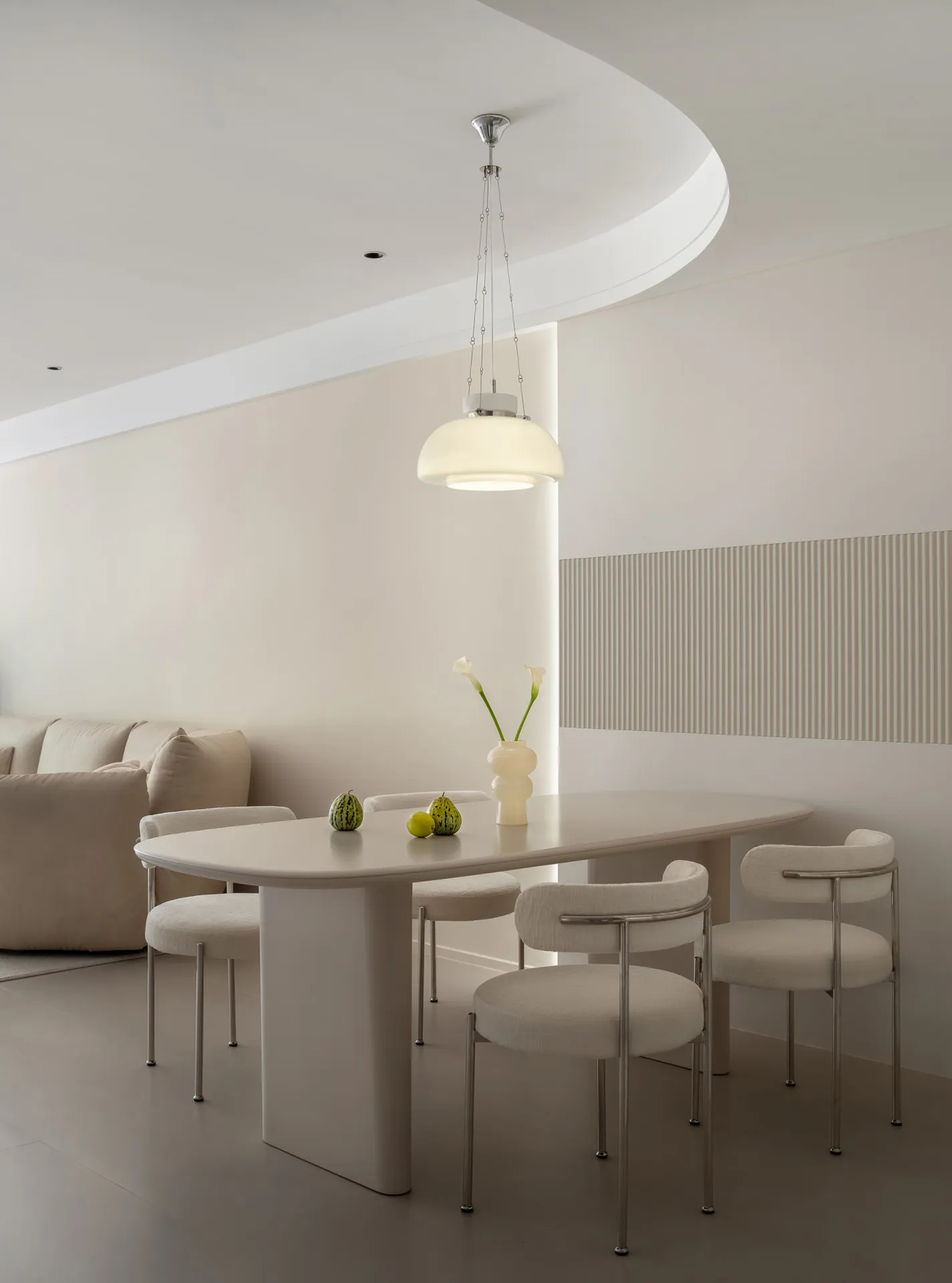 A modern dining room with white furniture and minimalist decor.