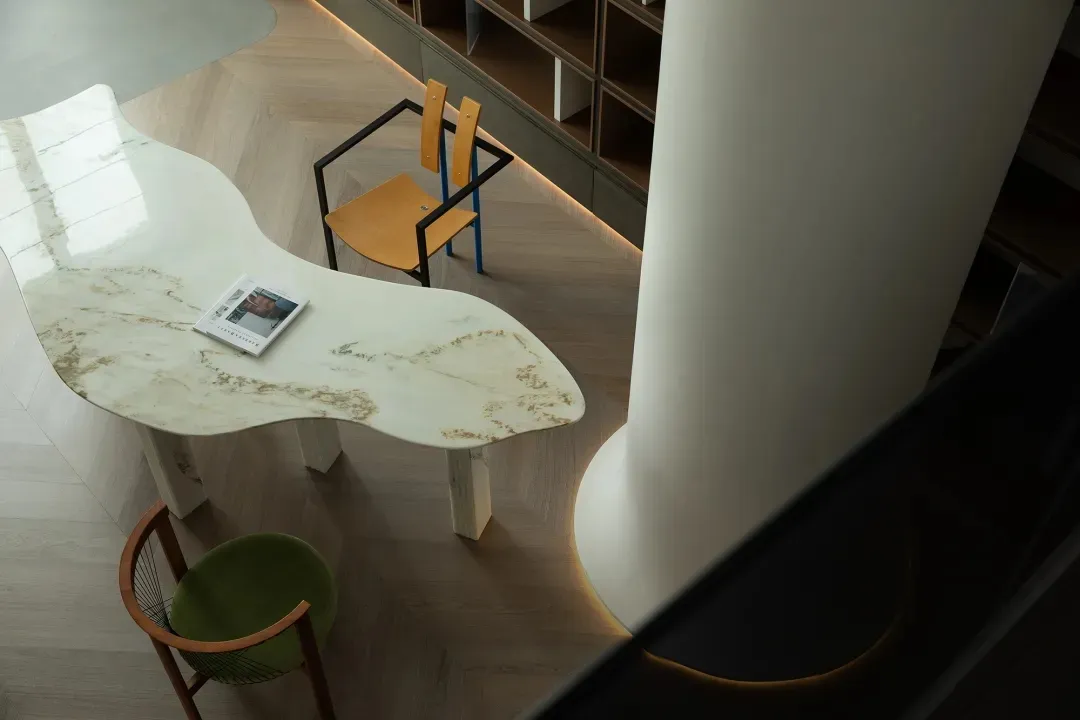 A modern, sleek desk made of marble with minimalist design and wooden accents in a home office setting.