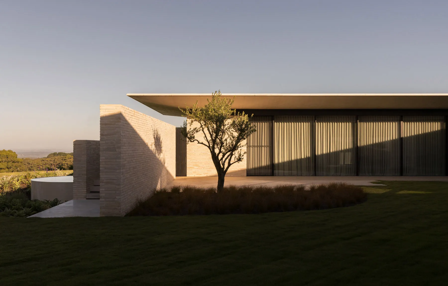 Modern residential house with brick and large glass windows.