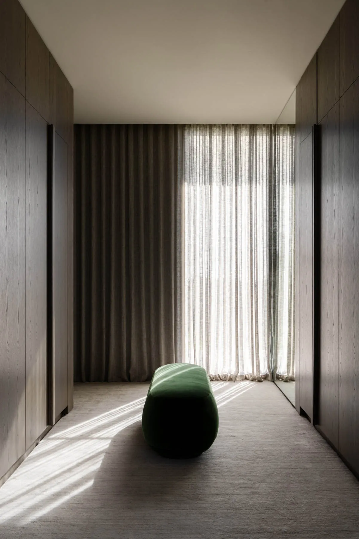 A modern interior space featuring light-colored textile curtains and warm lighting.