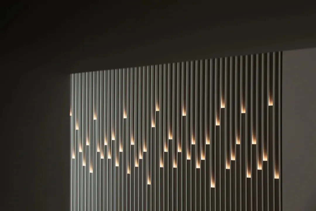 Modern interior wall featuring vertical metal strips with embedded lights.