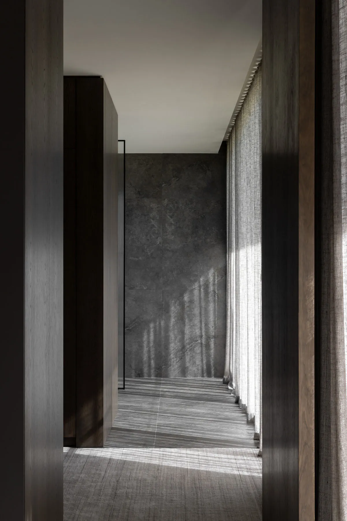 Modern residential interior with gray marble walls and glass partitions.
