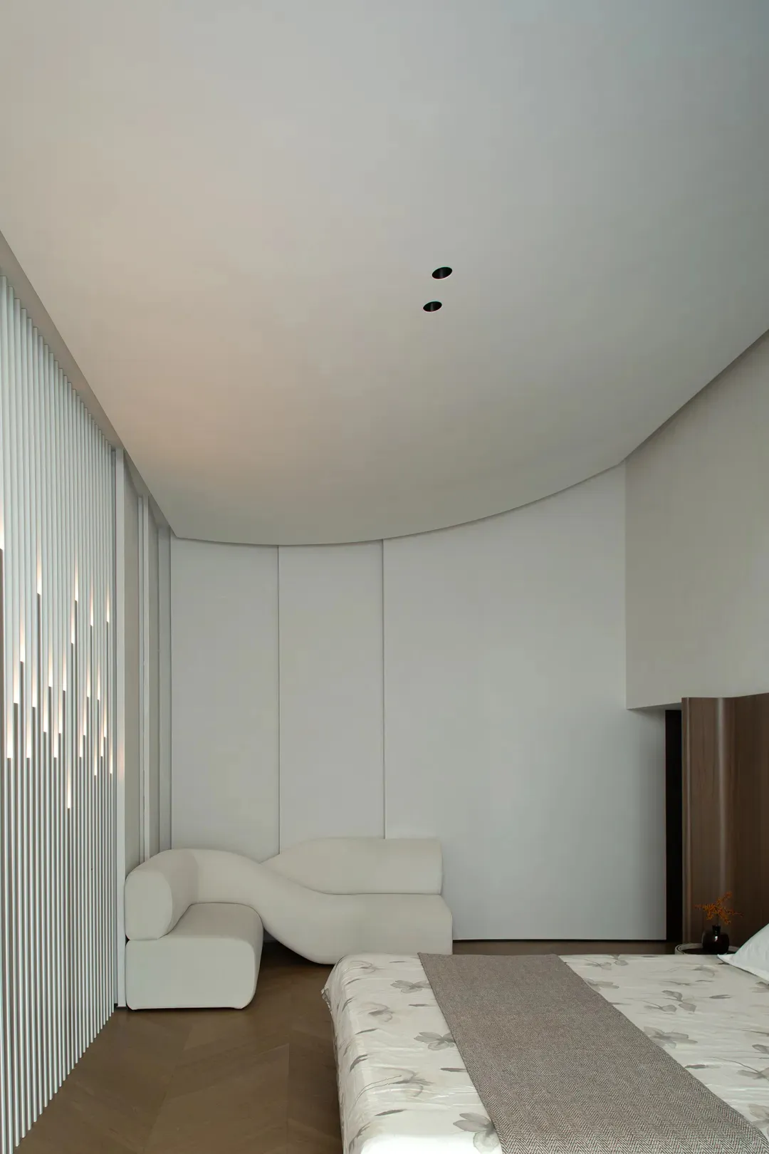 Neutral-toned minimalist bedroom with sleek lines and modern furniture.