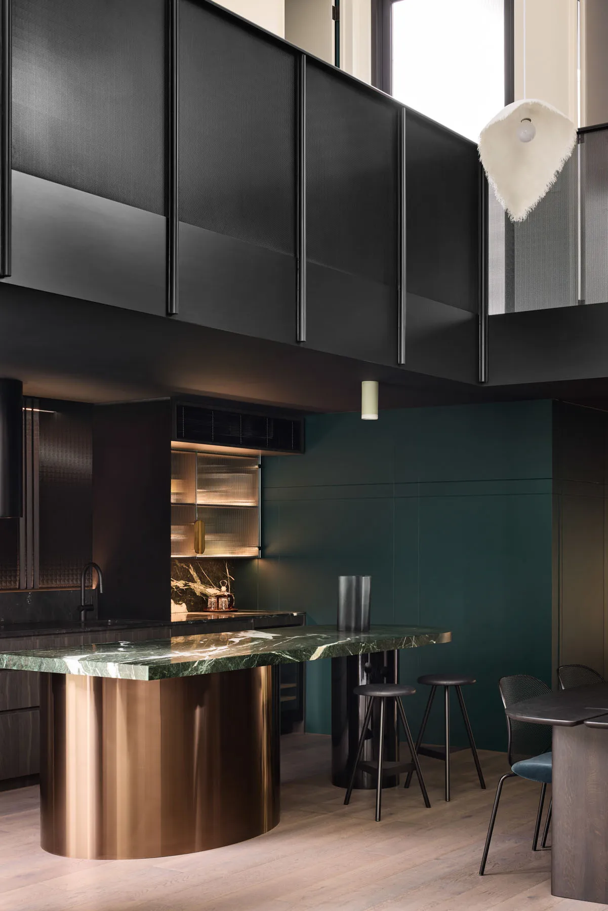 A modern kitchen featuring a marble counter and a copper pillar.
