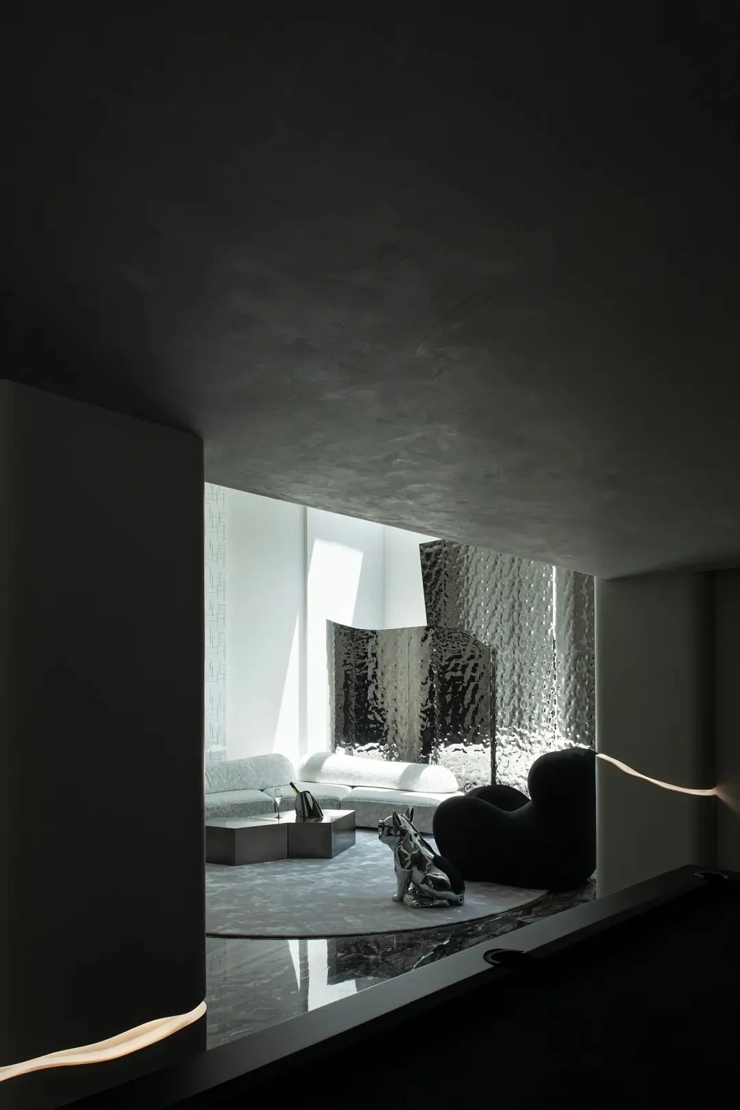 A minimalist living room with metallic-textured couches and black furniture. Modern and sleek design elements.