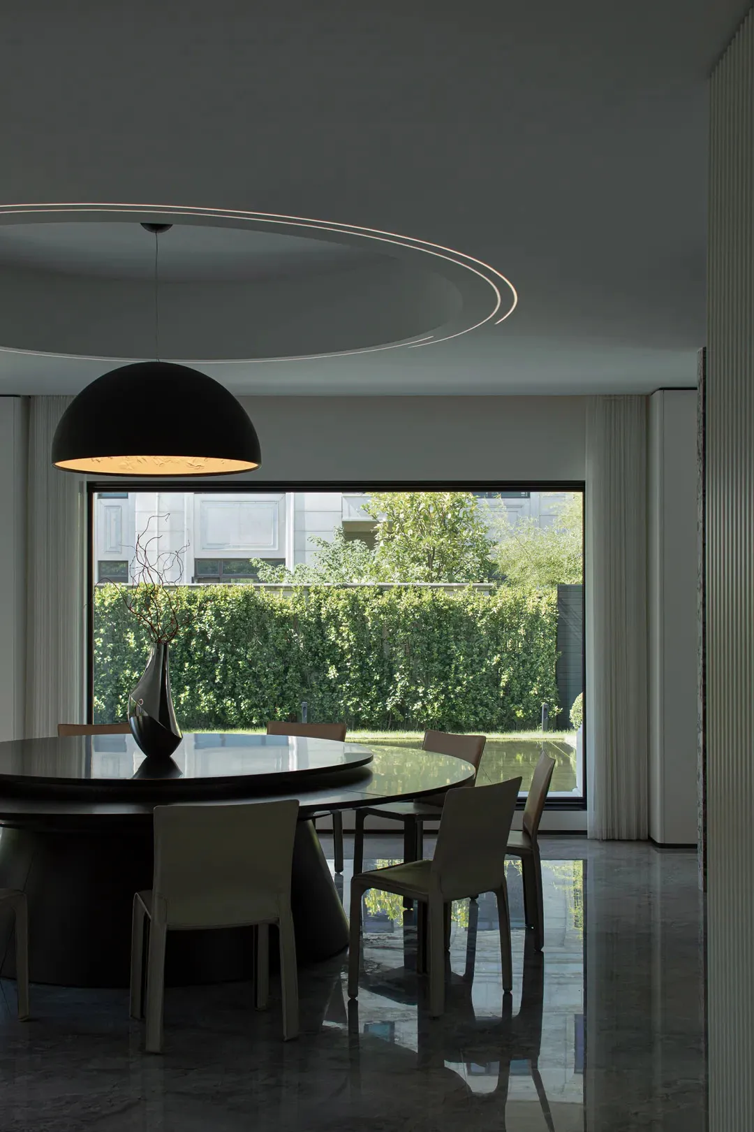 Modern dining room featuring a glass table and moon lighting.