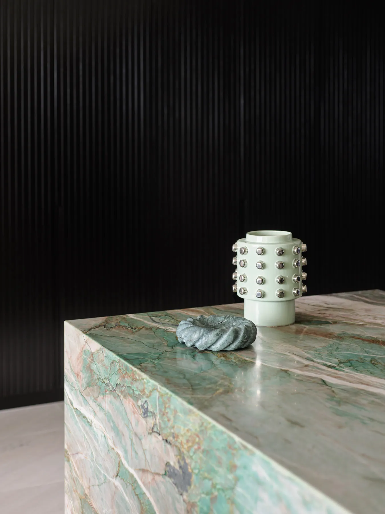 A modern-style, marble accessory with ceramic accents on a polished marble surface.
