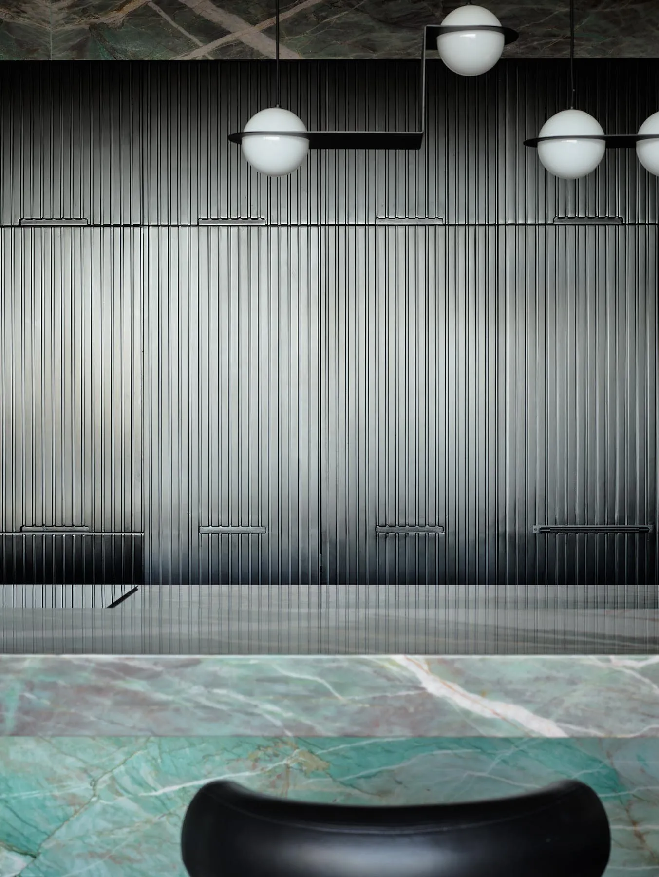 A modern minimalist interior with metallic panels and marble surfaces.