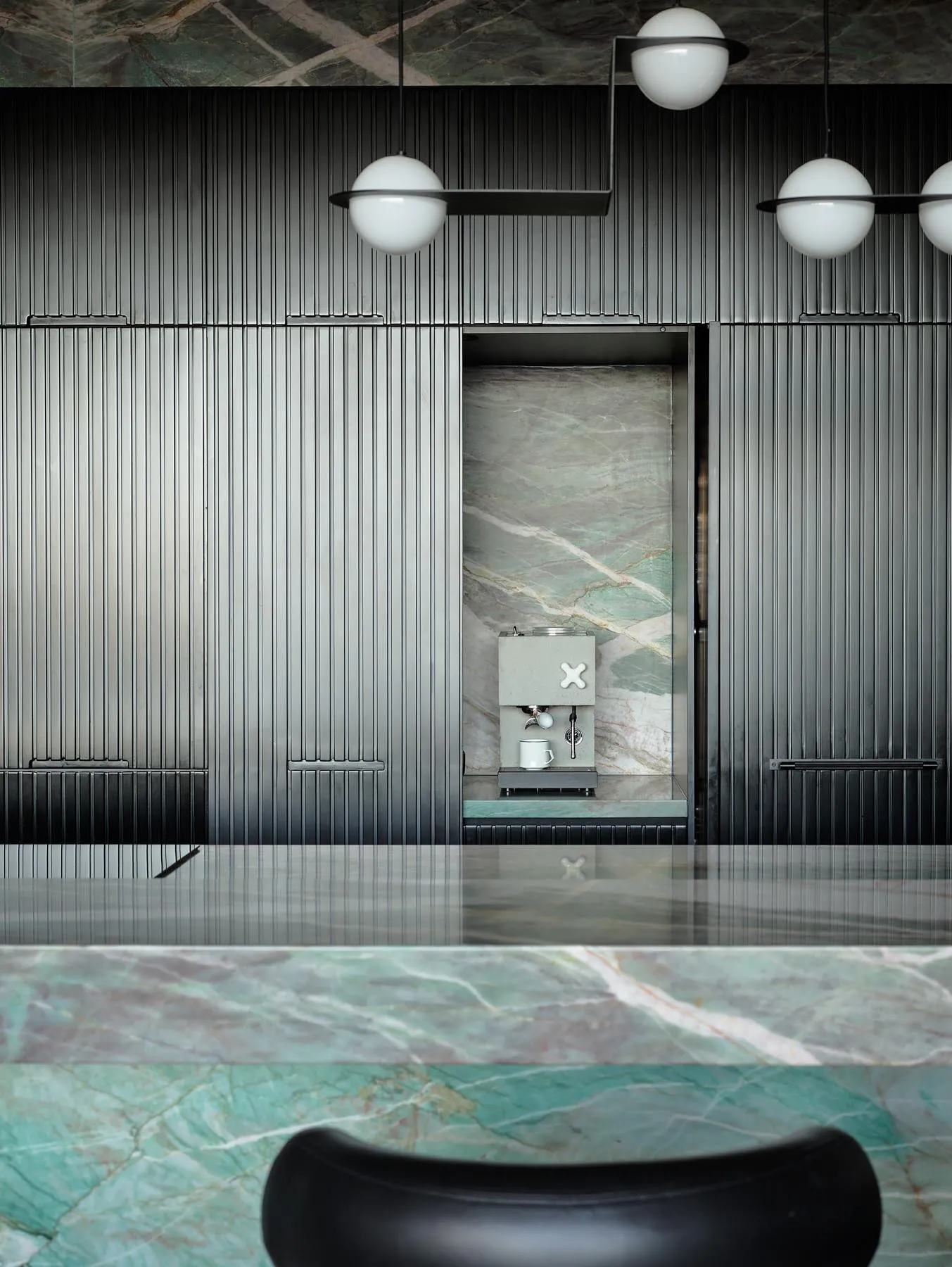 A minimalist coffee shop interior featuring a marble counter and modern design elements.