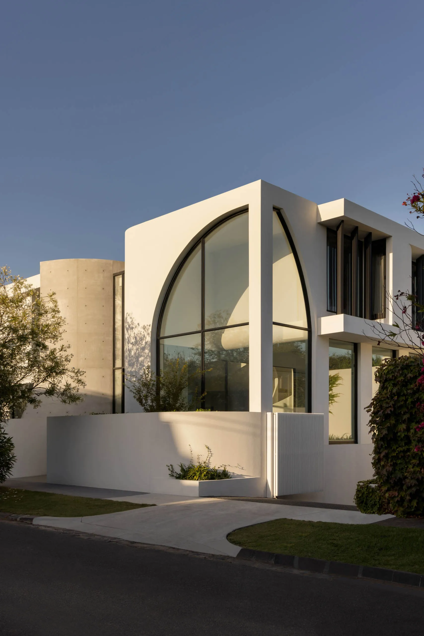 A modern residential building with a concrete exterior and large glass windows.