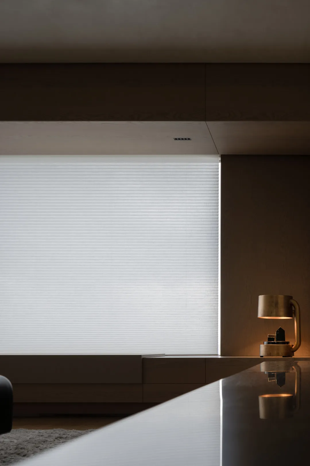A modern interior space featuring minimalist window blinds and sleek, contemporary design elements.