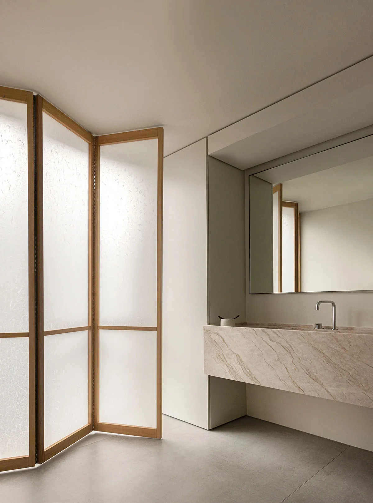 Modern bathroom featuring minimalist design with marble countertop, frosted-glass partitions, and wooden accents.