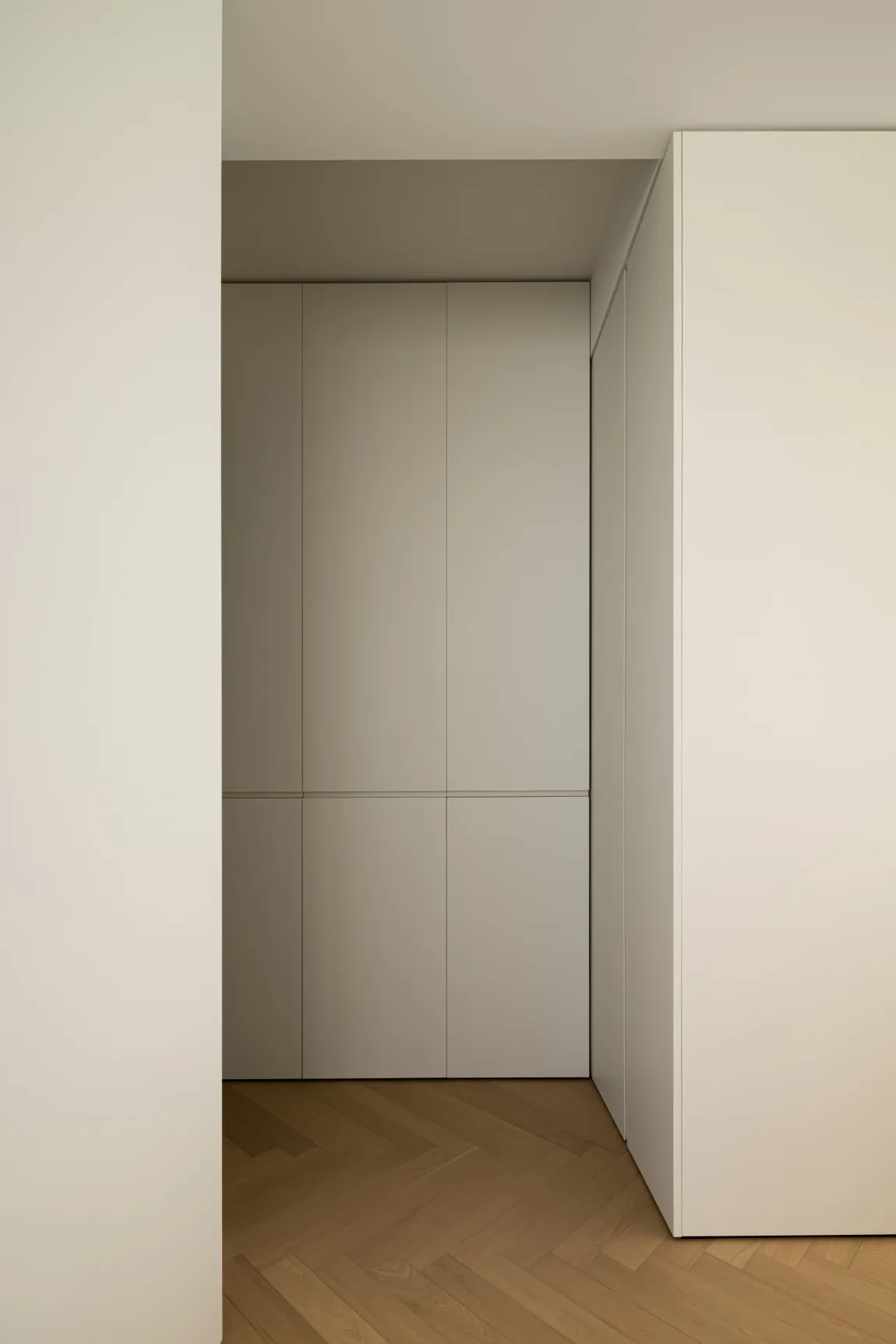 Modern, minimalist closet with white and light grey latex panels, showcasing sleek and functional design.