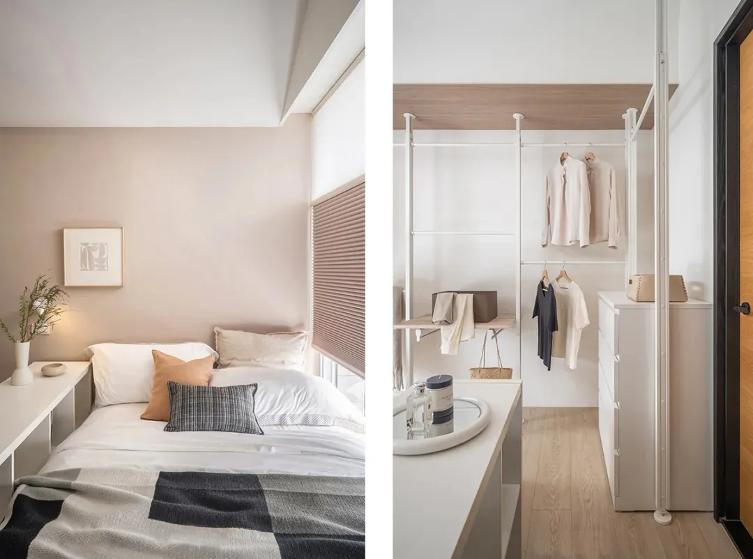 A minimalist bedroom featuring a walk-in wardrobe with a white shelf and hanging clothes, complemented by a white bed with ne