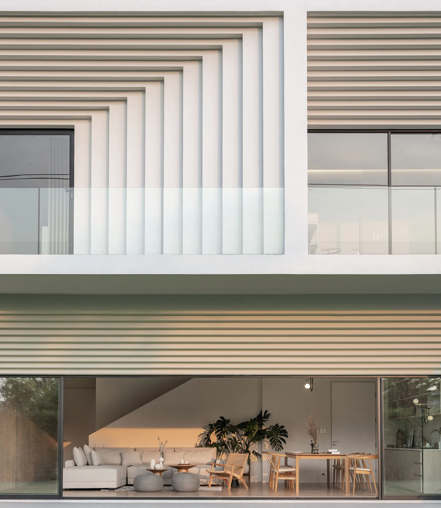 A modern residential building with a contemporary design featuring large glass windows and geometric patterns on the facade.