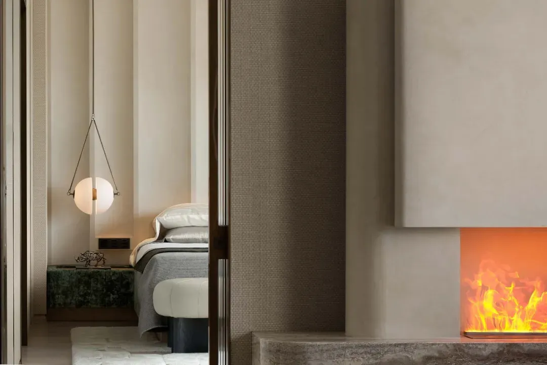 A minimalist bedroom with a concrete fireplace and white decor.