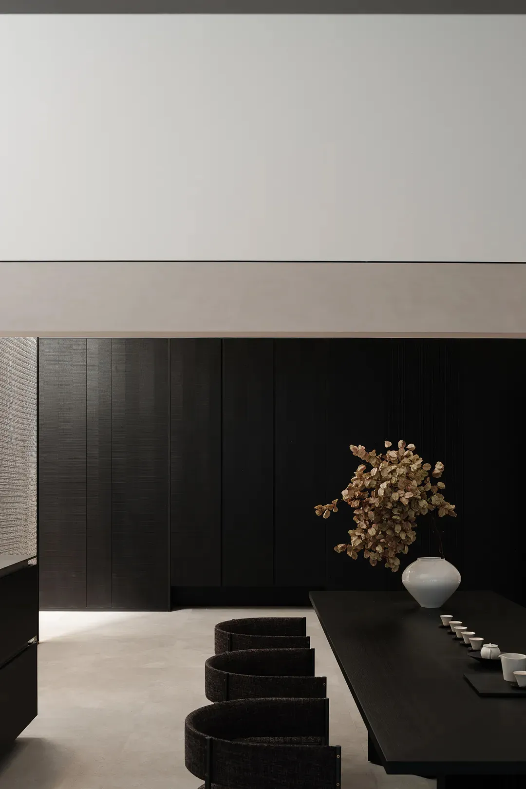 A modern living room featuring black wooden furniture and minimalist decor.