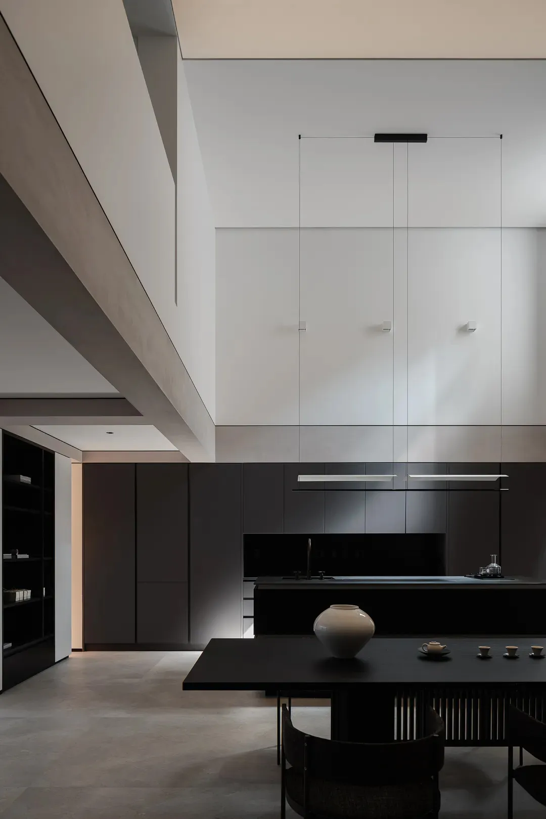 Modern residential kitchen with black cabinets and a large island.