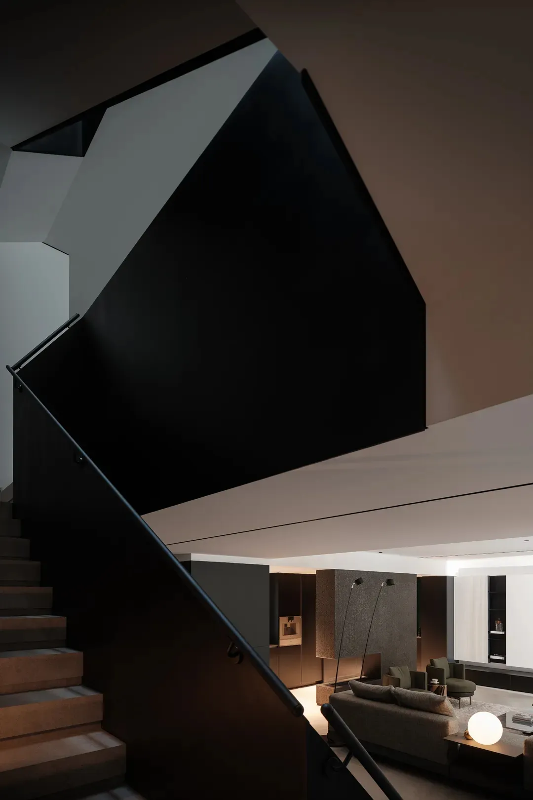 Modern residential staircase with black metal railing and concrete steps, featuring sleek design elements and contemporary st