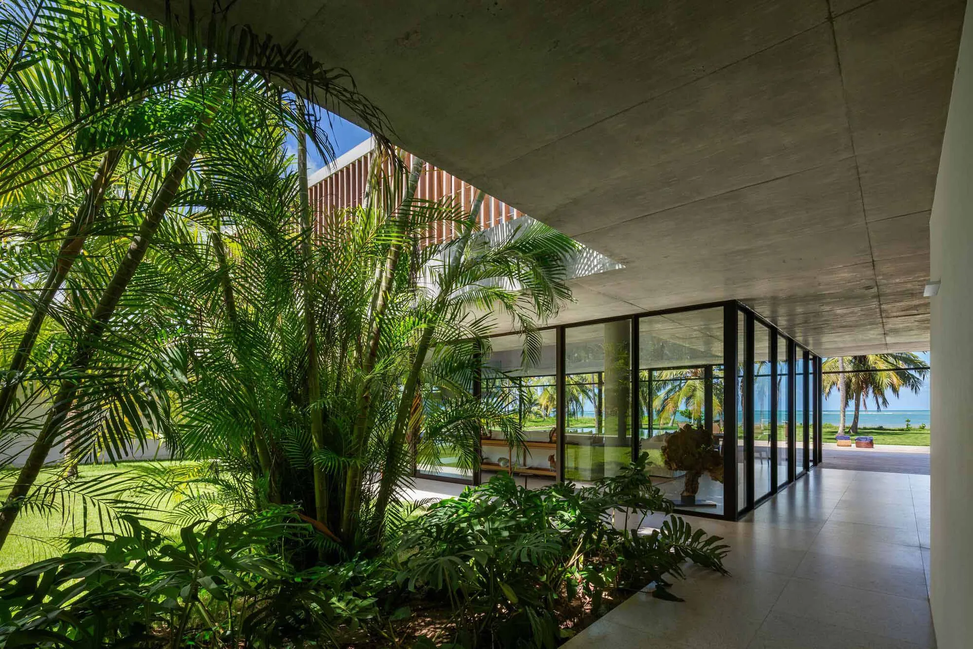 Modern house with concrete exterior and lush greenery in the backyard.