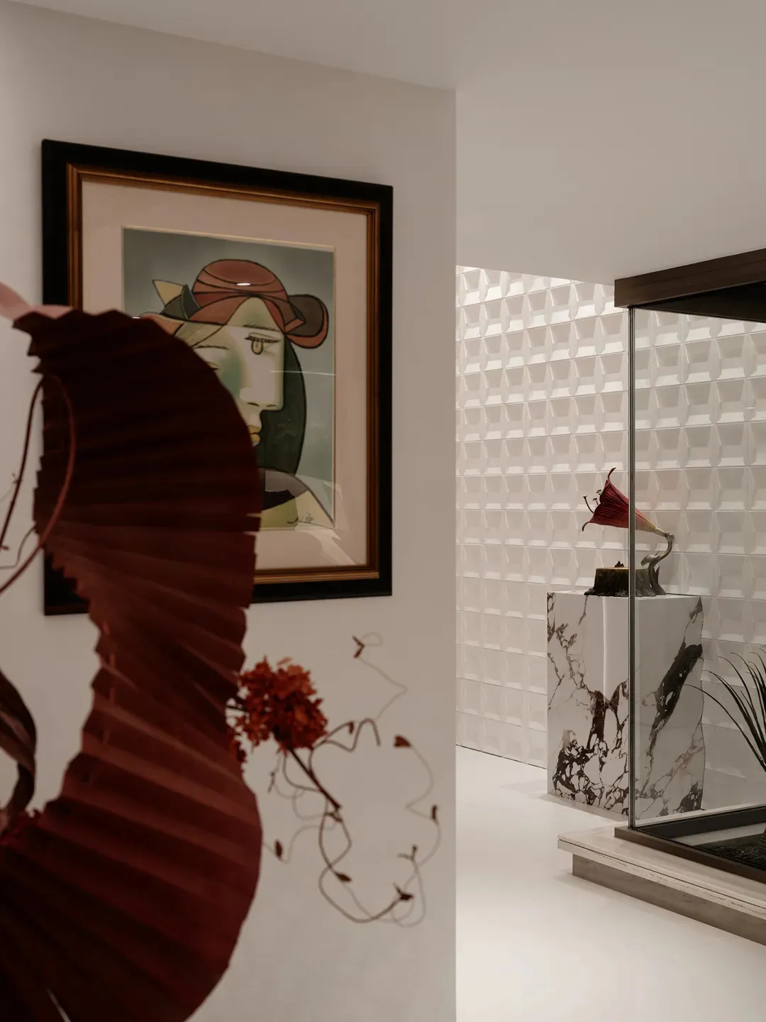 A stylish indoor space featuring a red decorative piece and framed art hanging on the wall.