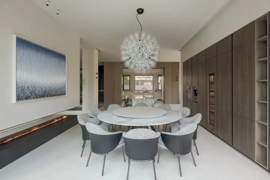 A contemporary living room with marble furniture and concrete flooring.