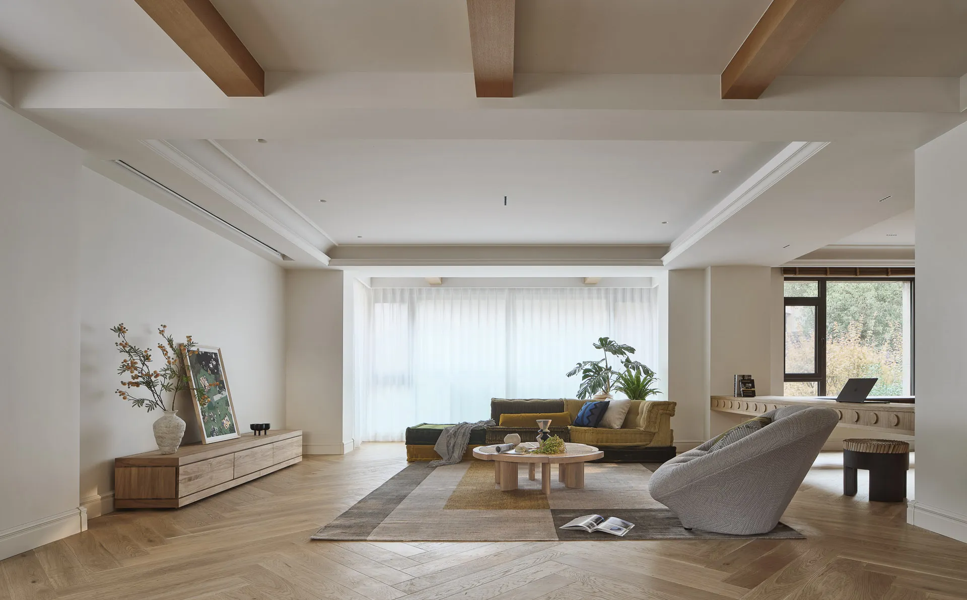 A modern minimalist living room featuring wood flooring and furniture, with a large window and plants.