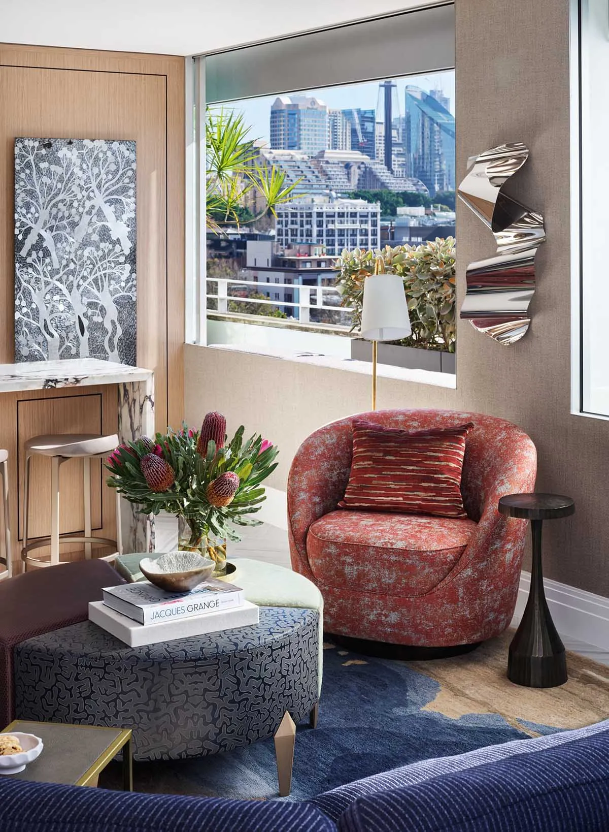 A modern interior design living room featuring indoor plants, a comfortable seating area, contemporary artwork, and a balcony