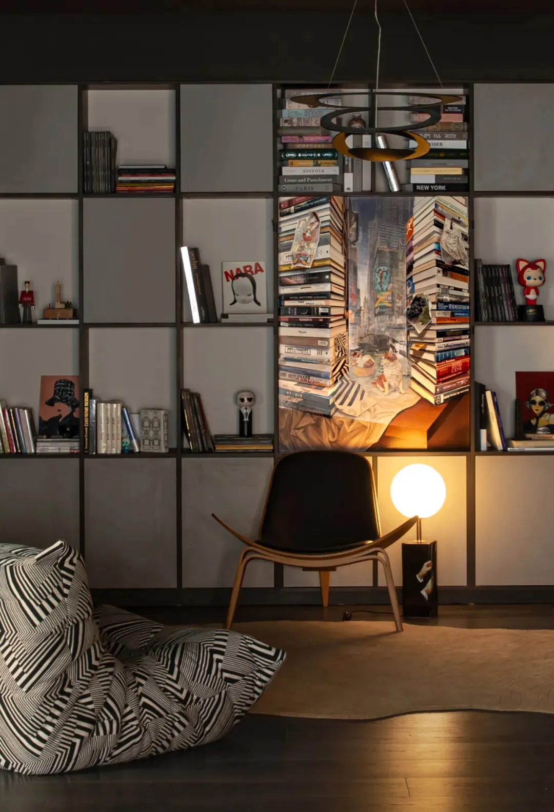 An industrial-style living room with a wooden armchair, bookshelf, and reading nook