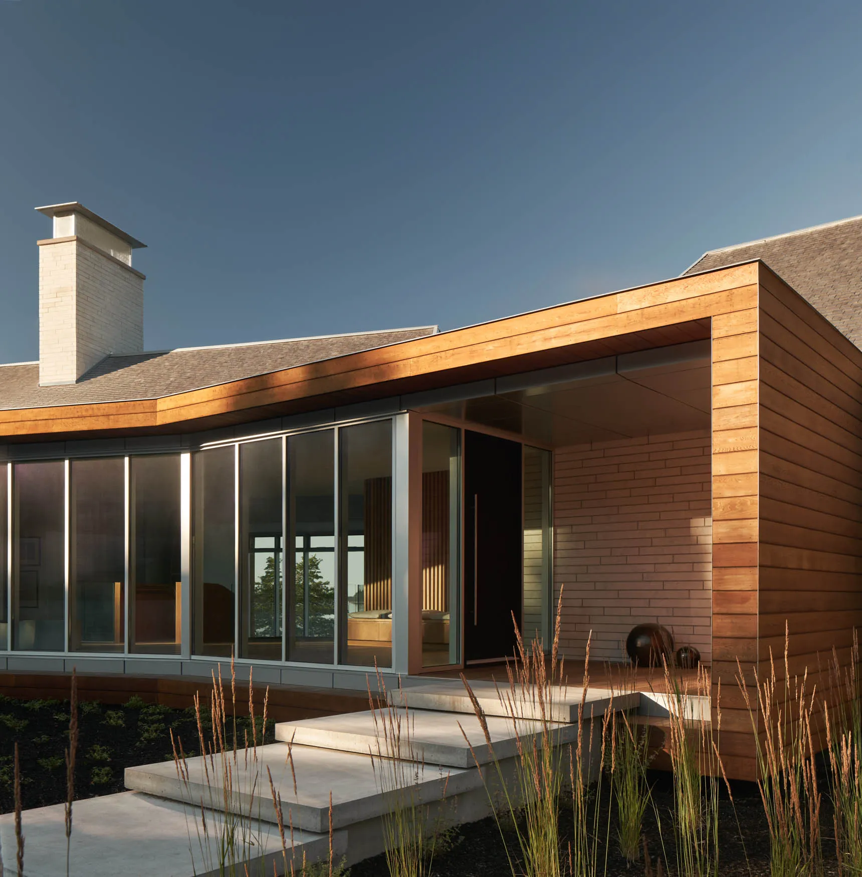 Modern residential house with wooden exterior and large windows.