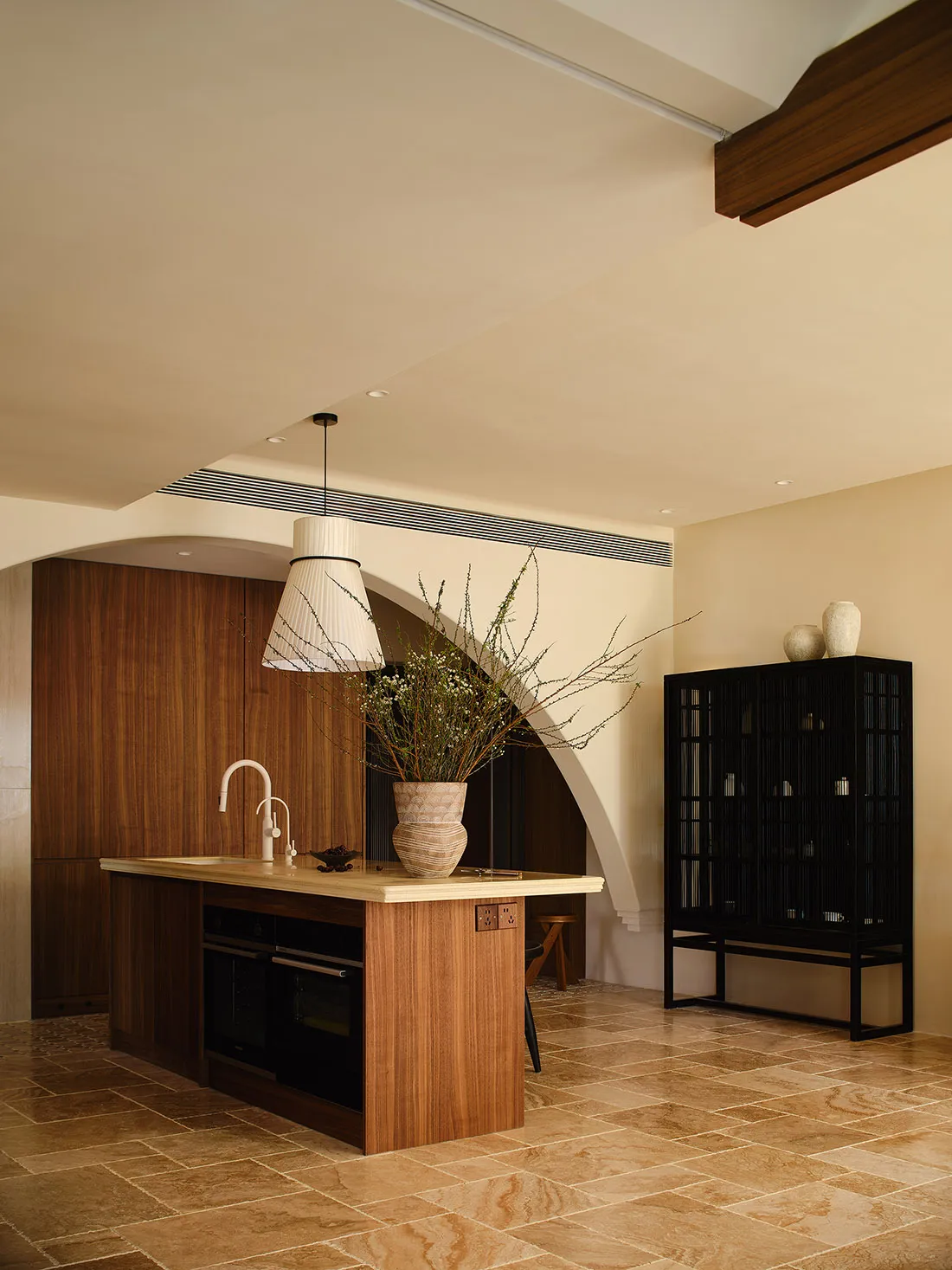 A modern minimalist kitchen featuring wooden cabinetry, marble countertops, and glass displays.