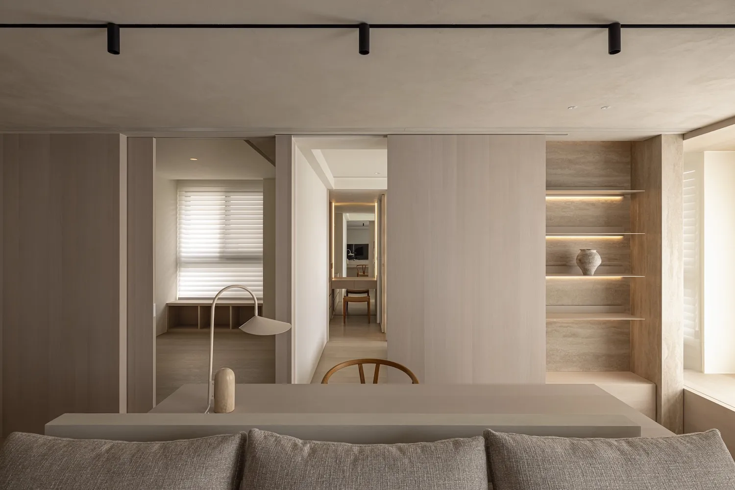 A modern minimalist living room featuring wooden elements and a neutral color palette.