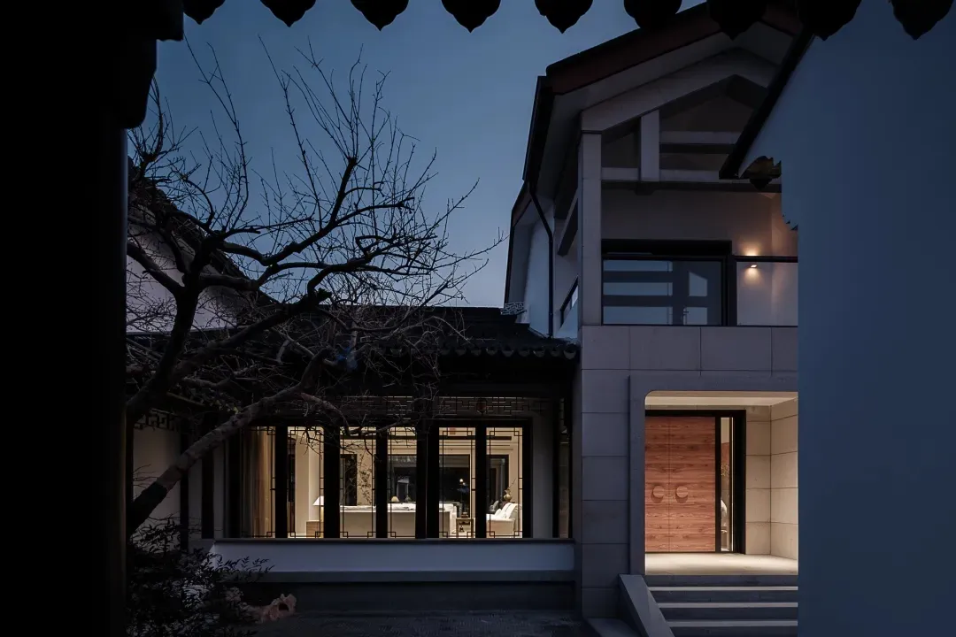 A modern residential exterior with concrete walls and wooden accents during dusk.