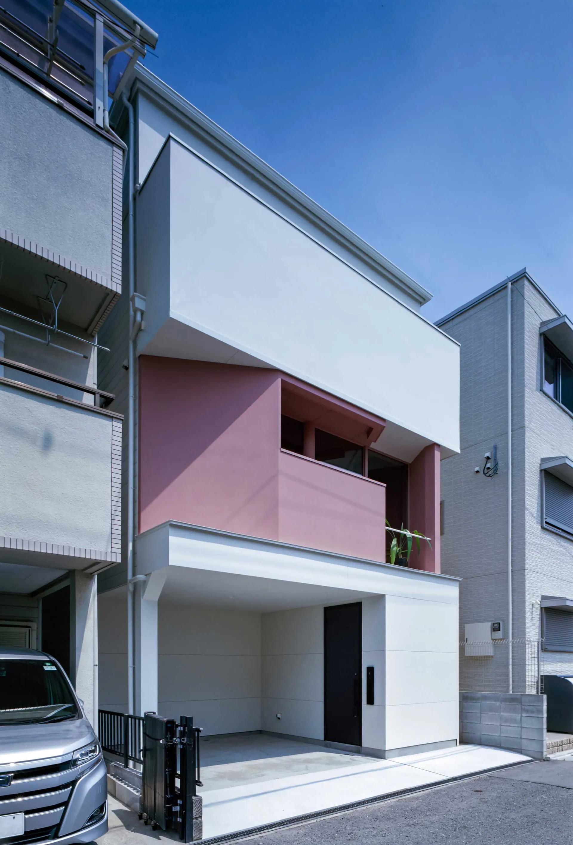 Modern residential exterior featuring concrete and glass materials.