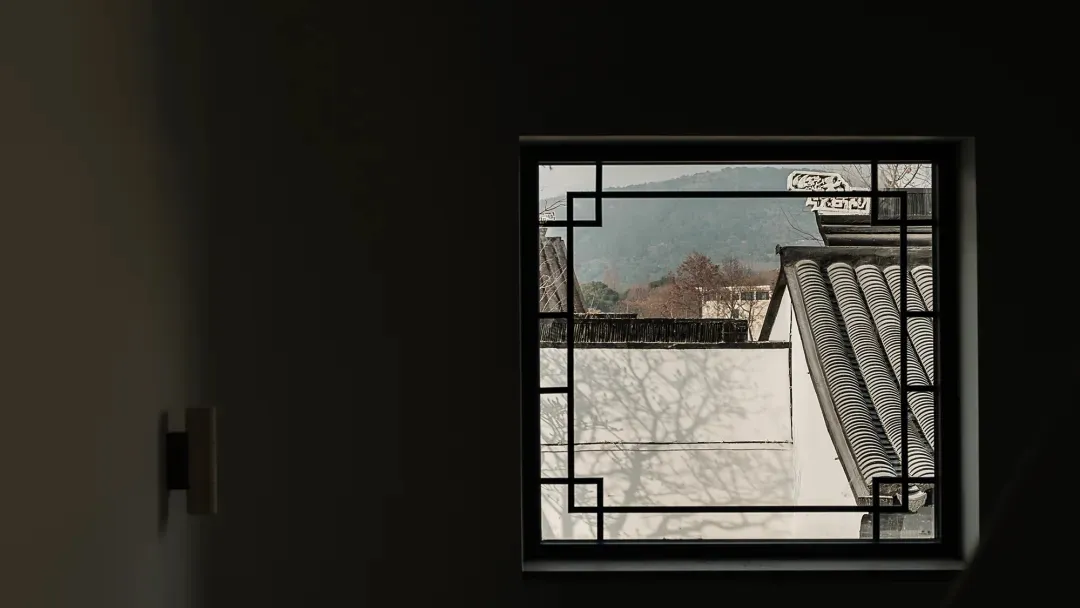 A modern window with a wooden frame overlooking a serene outdoor landscape.