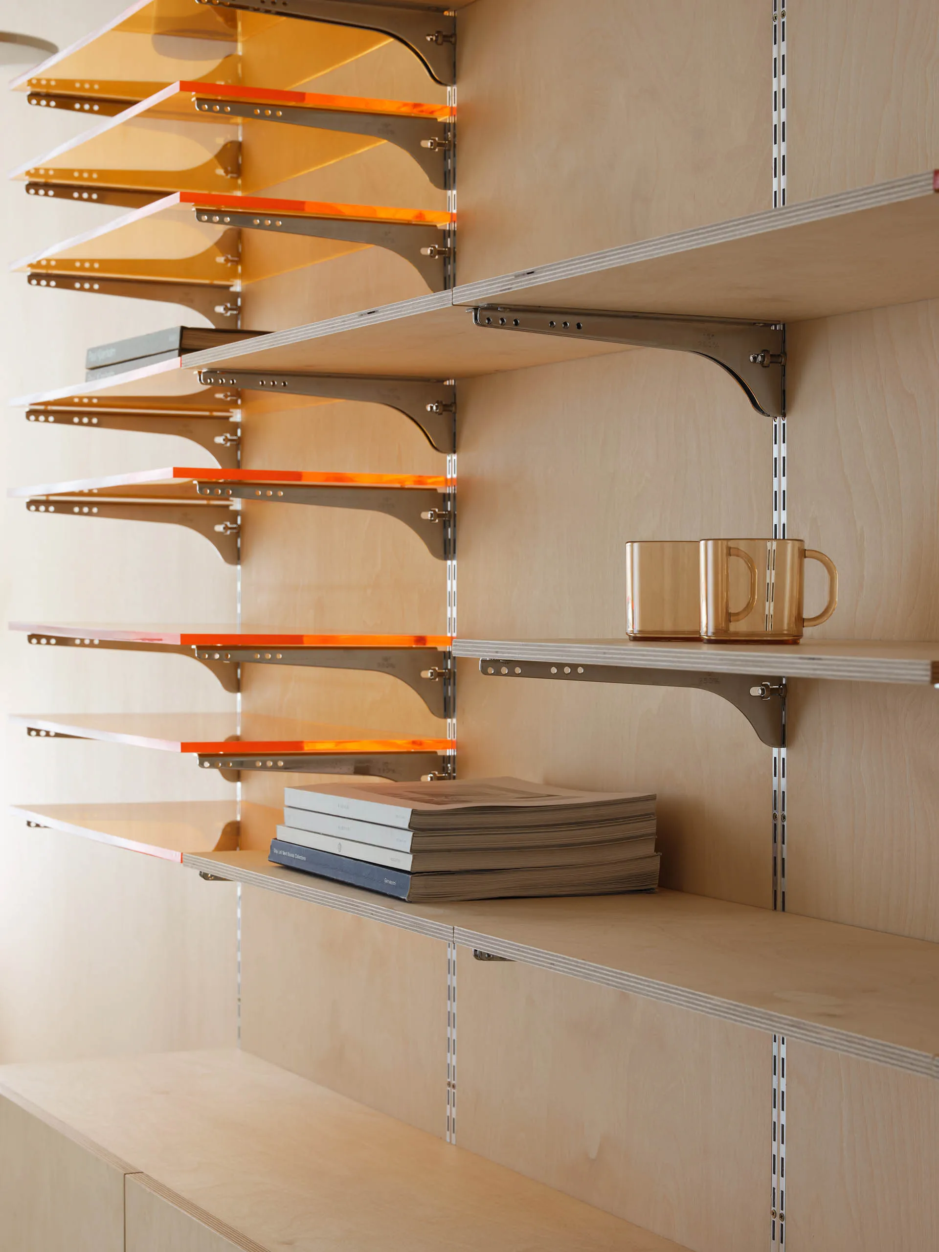Modern interior design featuring sleek wooden shelving units with metallic brackets.