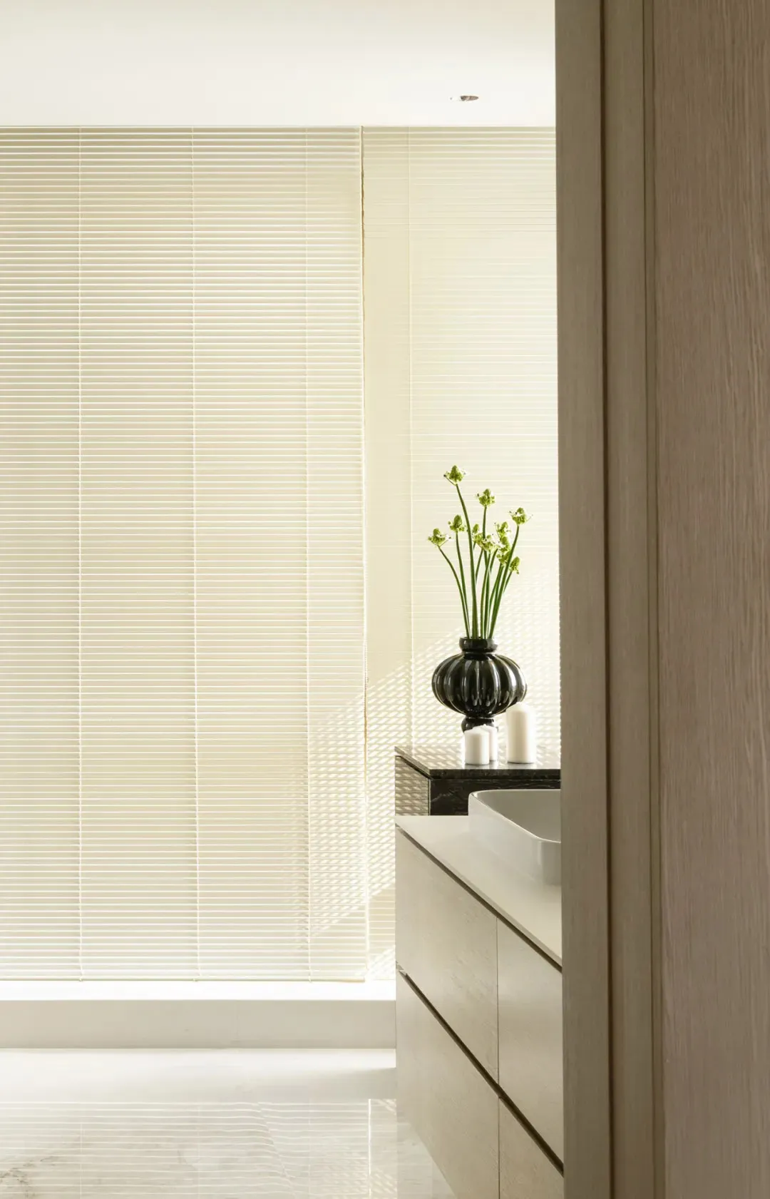 Modern minimalist bathroom features ceramic tiles and glass window blinds.