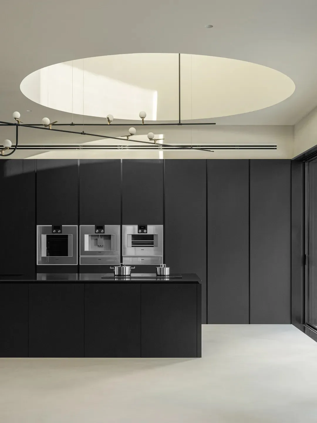 Contemporary minimalist kitchen with sleek black cabinetry and metallic appliances