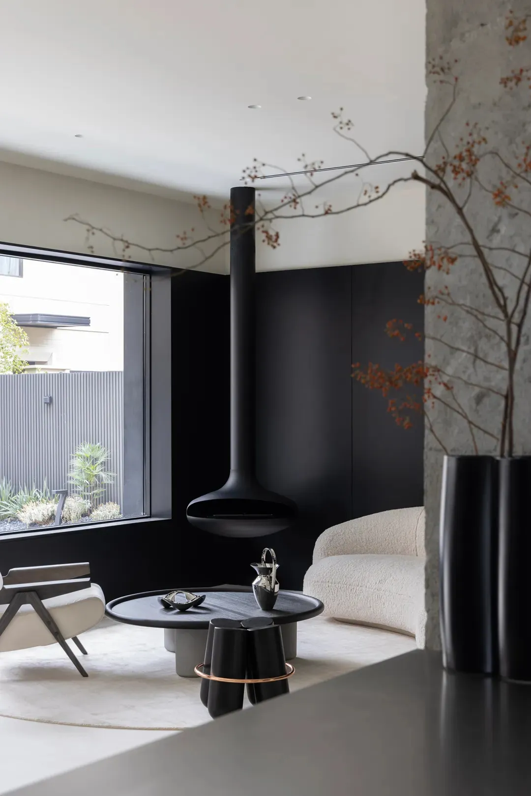 A minimalist living room with concrete walls and a modern fireplace.